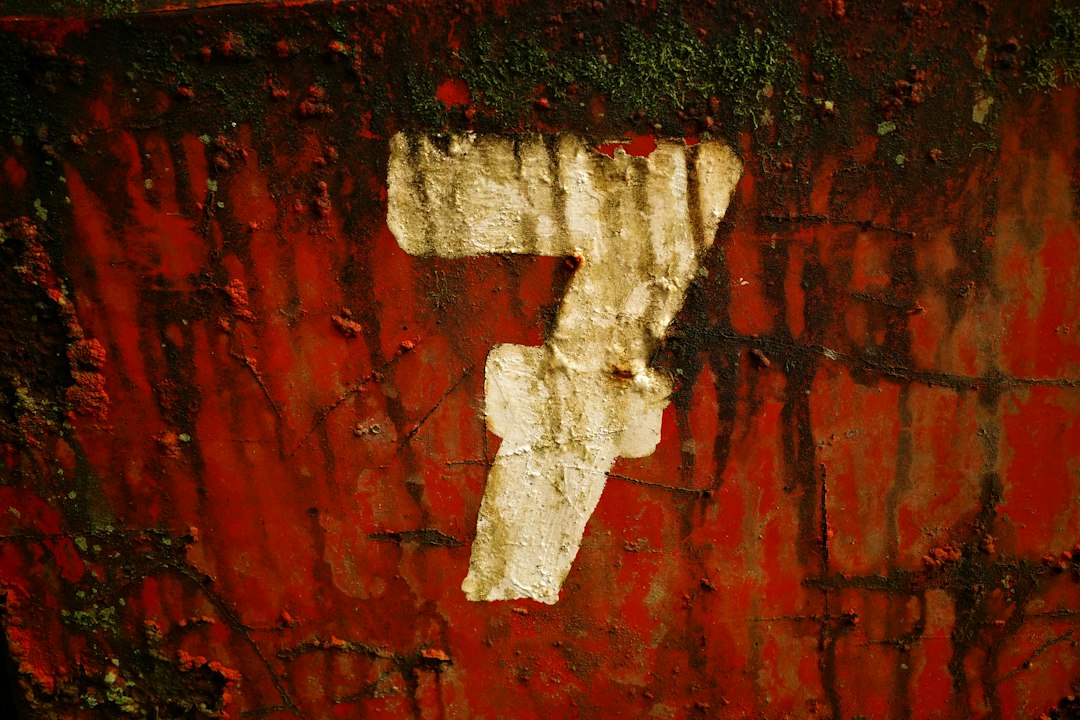 a number seven painted on a red wall