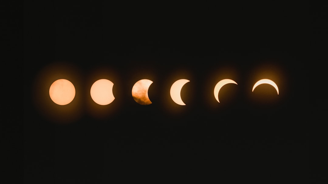 Six phases of a solar eclipse in a horizontal row against a black sky